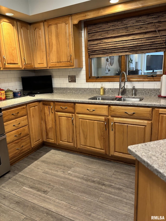 13916 Leisure Ln, Benton, IL 62812 - kitchen featuring a sink, backsplash, dark wood-type flooring, brown cabinets, and light stone countertops