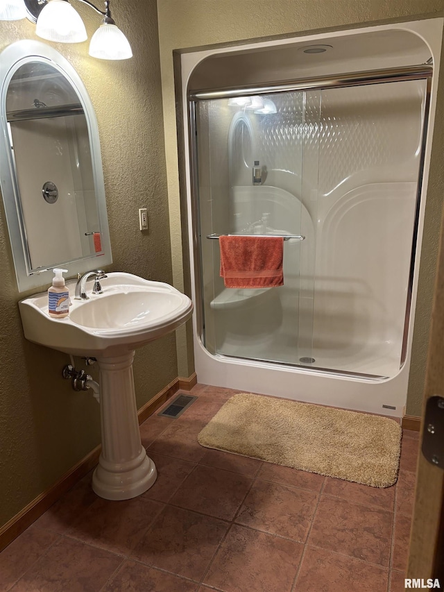 13916 Leisure Ln, Benton, IL 62812 - bathroom with a textured wall, a stall shower, baseboards, and tile patterned floors