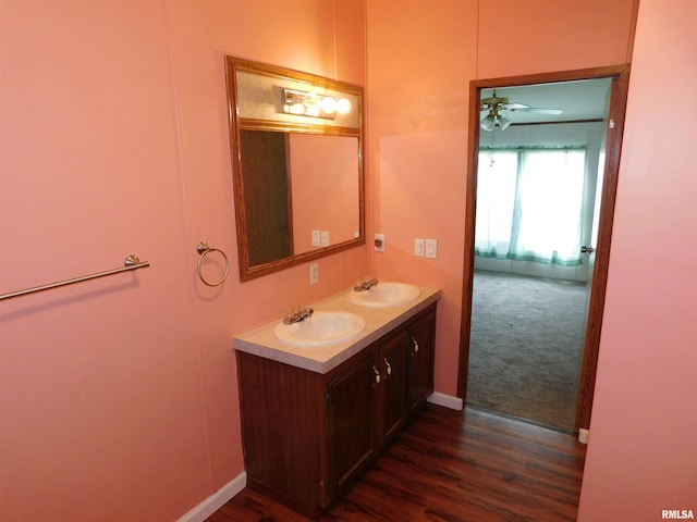 403 E Sycamore St, Kinmundy, IL 62854 - bathroom with double vanity, a ceiling fan, wood finished floors, and baseboards