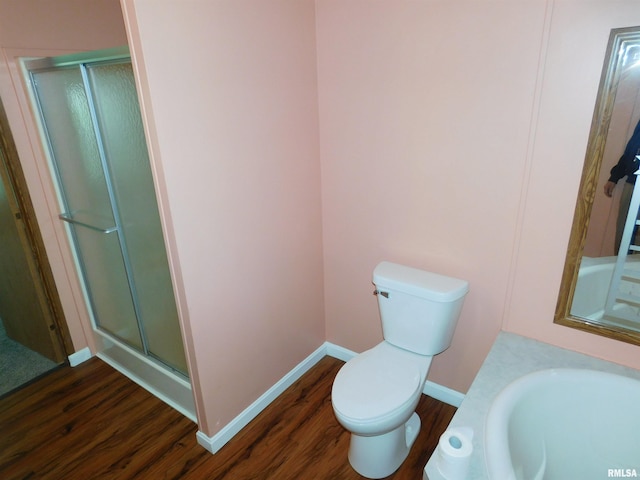 403 E Sycamore St, Kinmundy, IL 62854 - bathroom with wood finished floors, a stall shower, toilet, baseboards, and a sink