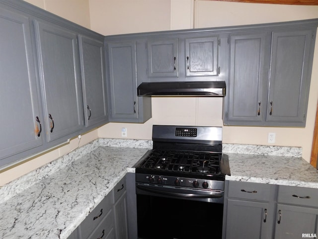 403 E Sycamore St, Kinmundy, IL 62854 - kitchen with gas range, gray cabinetry, under cabinet range hood, and light stone counters