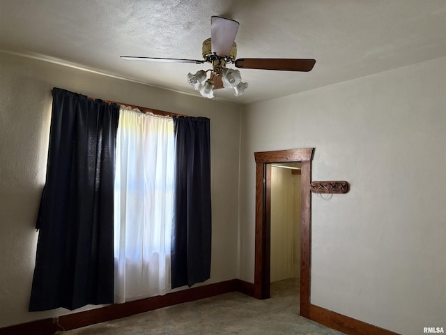 spare room with ceiling fan and baseboards