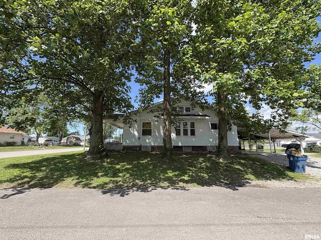 bungalow-style house with a detached carport and driveway
