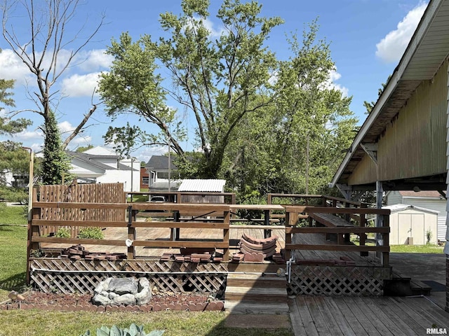 wooden deck featuring a shed and an outdoor structure