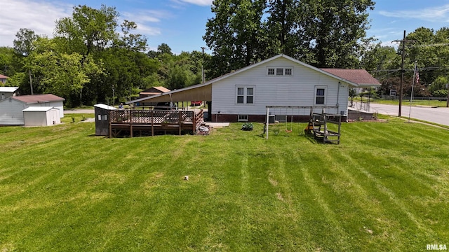 back of house featuring a storage shed, a deck, an outbuilding, and a lawn
