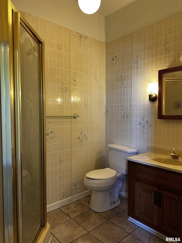 402 S Main St, Benton, IL 62812 - bathroom featuring tile walls, toilet, tile patterned floors, a stall shower, and vanity