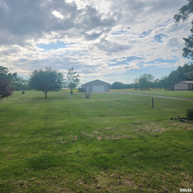 15267 N Woodlawn Ln, Woodlawn, IL 62898 - view of green lawn with a rural view, an outbuilding, and a garage