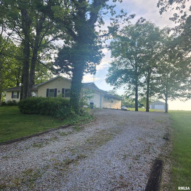 15267 N Woodlawn Ln, Woodlawn, IL 62898 - view of side of home with gravel driveway, a lawn, and an attached garage