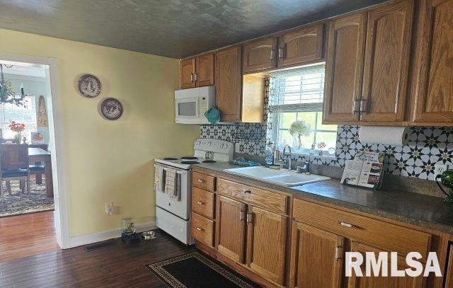 160 Front St, Elizabethtown, IL 62931 - kitchen featuring white appliances, a sink, dark wood-style floors, decorative backsplash, and baseboards