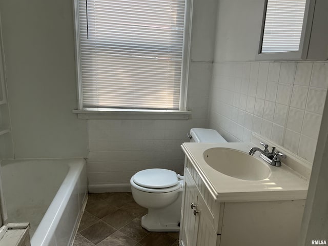 404 W Elm St, Carbondale, IL 62901 - bathroom with tile walls, toilet, a tub, and vanity