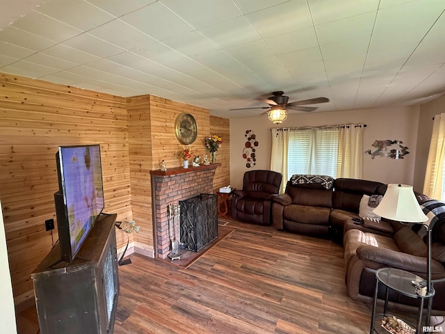 6556 S US-45 Rd, Brookport, IL 62910 - living room with wooden walls, dark wood-style flooring, ceiling fan, and a fireplace