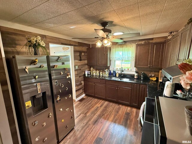 6556 S US-45 Rd, Brookport, IL 62910 - kitchen with a sink, dark countertops, wooden walls, dark wood-type flooring, and ceiling fan