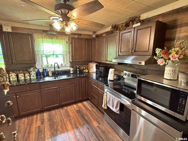 6556 S US-45 Rd, Brookport, IL 62910 - kitchen featuring appliances with stainless steel finishes, range hood, a sink, dark countertops, and a ceiling fan