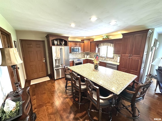 23208 N US Highway 51, Centralia, IL 62801 - kitchen with appliances with stainless steel finishes, a sink, dark wood-style floors, and a kitchen island