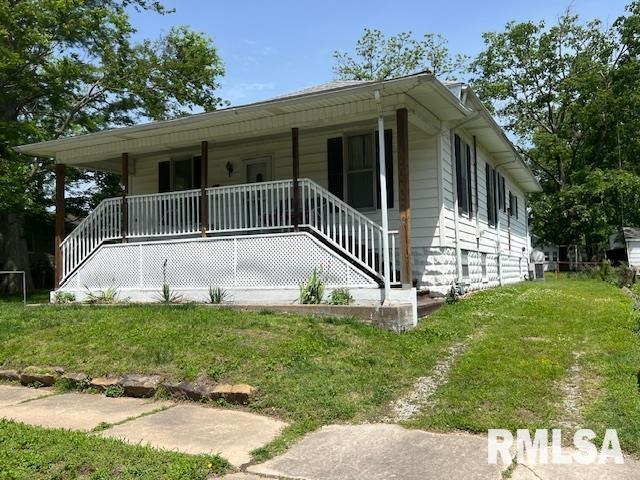 view of front of house featuring a porch, a front yard, and stairs