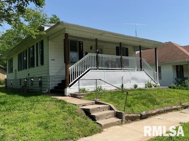 view of front of home with a front lawn, stairway, and a porch