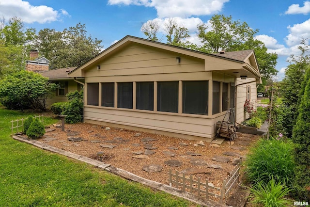 2605 W Sunset Dr, Carbondale, IL 62901 - rear view of house with a sunroom and a chimney