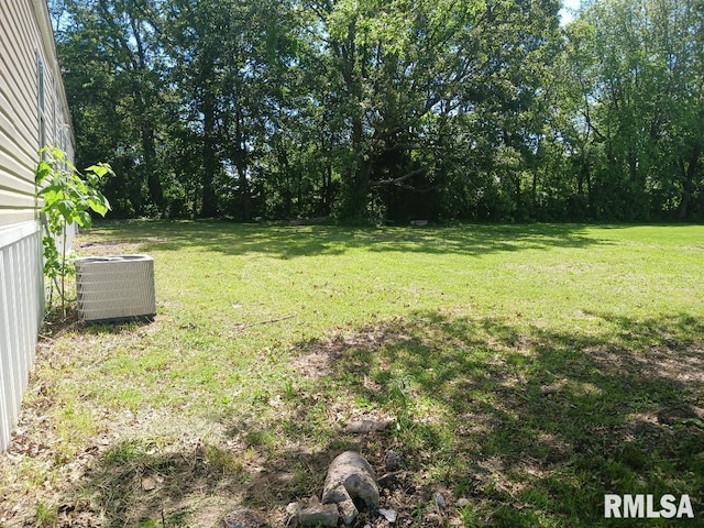 view of grassy yard featuring central air condition unit