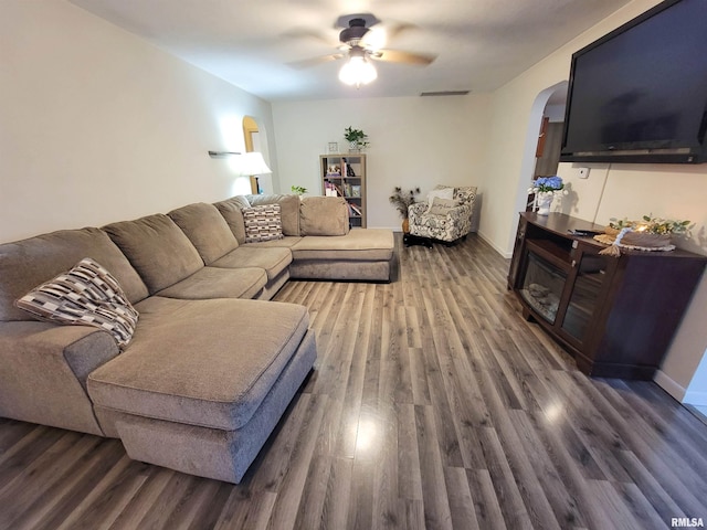 214 W 12th St, Flora, IL 62839 - living room featuring arched walkways, wood finished floors, a ceiling fan, and baseboards
