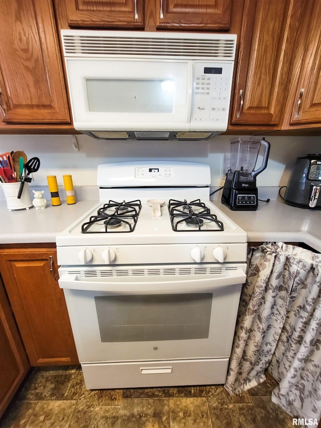 214 W 12th St, Flora, IL 62839 - kitchen with white appliances, brown cabinets, and light countertops