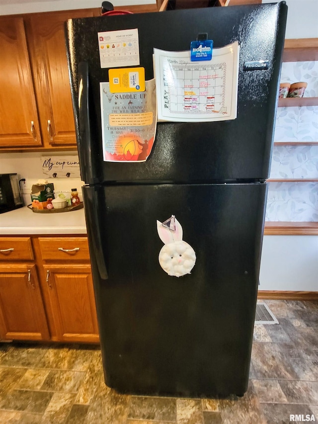 214 W 12th St, Flora, IL 62839 - detailed view of freestanding refrigerator, brown cabinetry, and light countertops