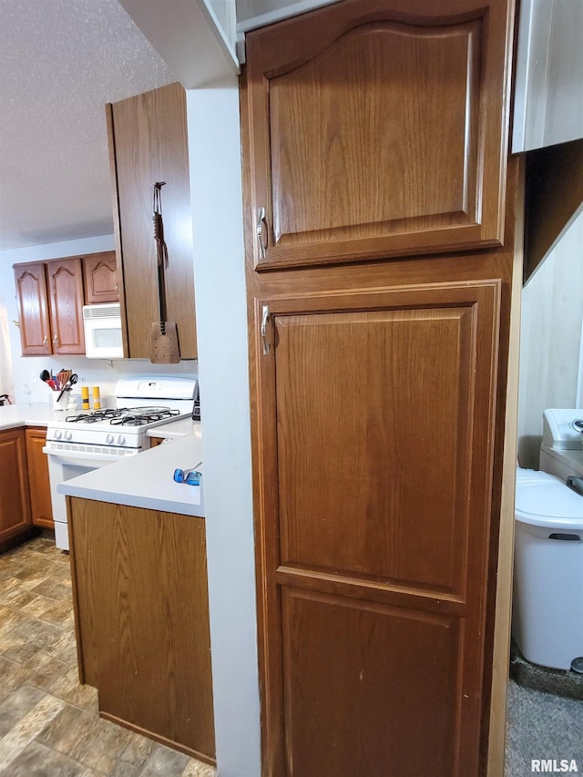 214 W 12th St, Flora, IL 62839 - kitchen featuring white appliances, brown cabinets, light countertops, and a textured ceiling