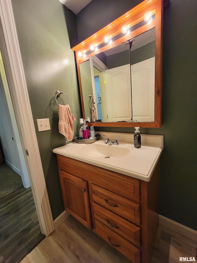 214 W 12th St, Flora, IL 62839 - bathroom with wood finished floors, vanity, and baseboards