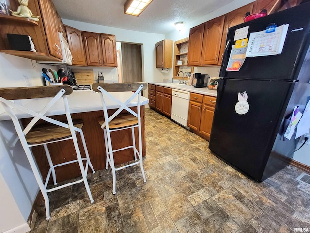 214 W 12th St, Flora, IL 62839 - kitchen with open shelves, white appliances, dark stone finish flooring, a sink, and a peninsula