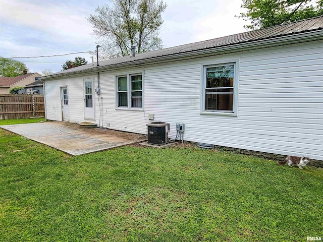 214 W 12th St, Flora, IL 62839 - back of house featuring a patio, cooling unit, and metal roof