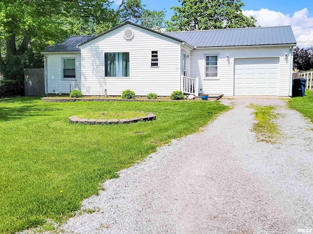 214 W 12th St, Flora, IL 62839 - ranch-style home with driveway, an attached garage, metal roof, and a front lawn
