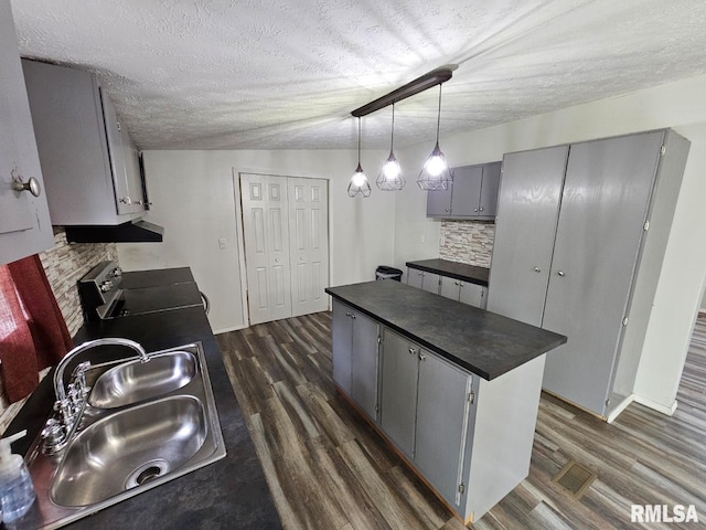 901 W 4th St, Bluford, IL 62814 - kitchen featuring gray cabinets, dark countertops, stove, a sink, and dark wood-style flooring
