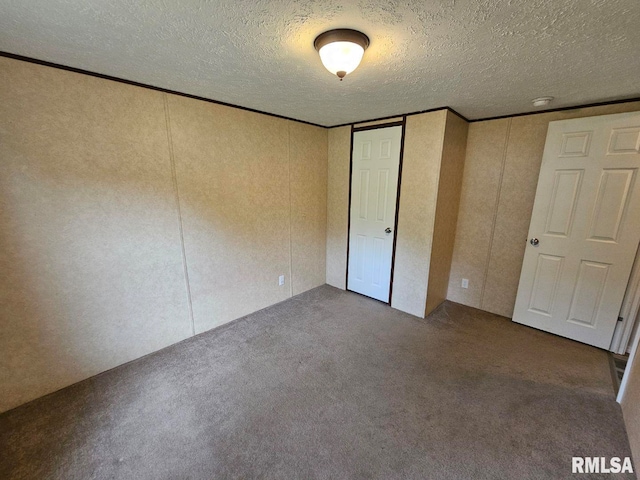 901 W 4th St, Bluford, IL 62814 - unfurnished bedroom with carpet floors, a textured ceiling, crown molding, and a decorative wall