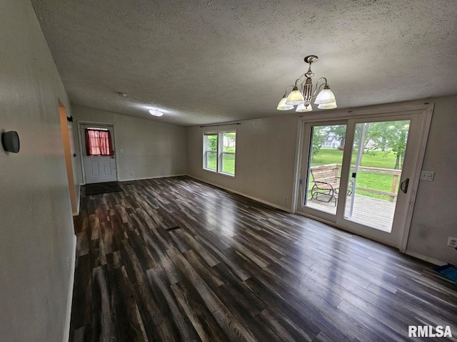 901 W 4th St, Bluford, IL 62814 - spare room featuring dark wood-type flooring, a textured ceiling, baseboards, a chandelier, and vaulted ceiling