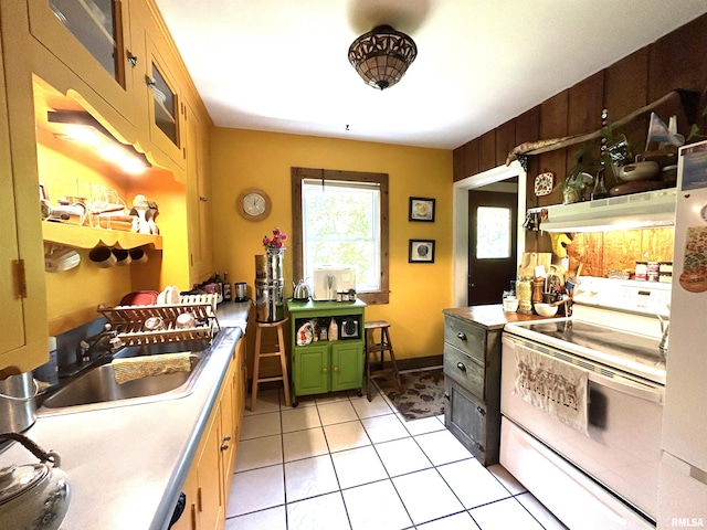 kitchen featuring white range with electric cooktop, under cabinet range hood, a sink, green cabinets, and light tile patterned floors