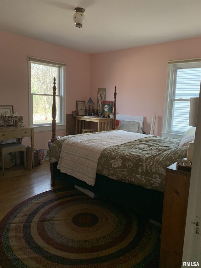 bedroom featuring wood finished floors and a desk