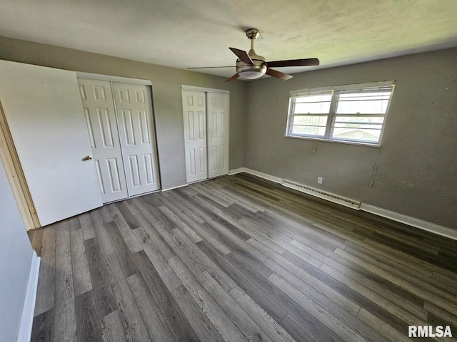 2 Parker Dr, Mount Vernon, IL 62864 - unfurnished bedroom with baseboard heating, multiple closets, dark wood-type flooring, and baseboards