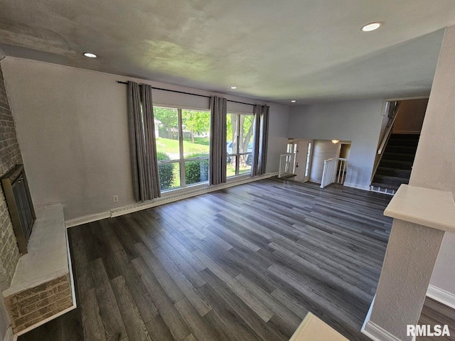 2 Parker Dr, Mount Vernon, IL 62864 - unfurnished living room with dark wood-type flooring, a brick fireplace, stairs, recessed lighting, and baseboards