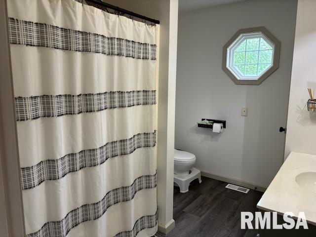 1500 Saint Andrews Pl, Herrin, IL 62948 - full bath featuring wood finished floors, baseboards, toilet, a sink, and curtained shower