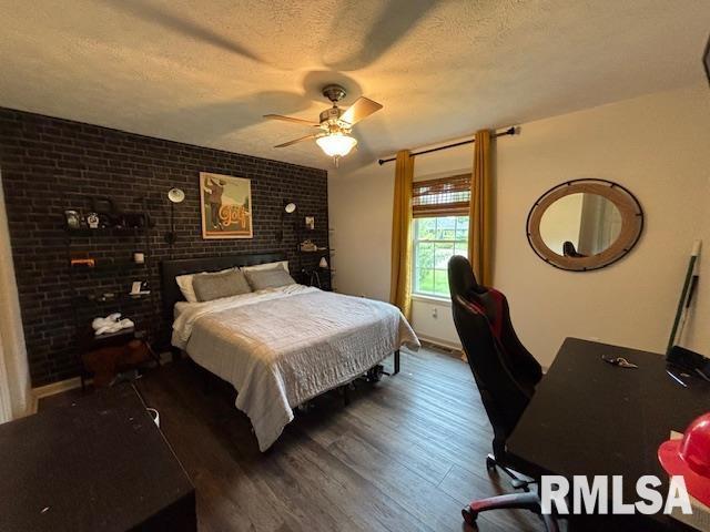 1500 Saint Andrews Pl, Herrin, IL 62948 - bedroom with wood finished floors, a textured ceiling, a ceiling fan, and brick wall