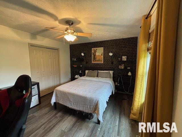 1500 Saint Andrews Pl, Herrin, IL 62948 - bedroom with wood finished floors, brick wall, a closet, a ceiling fan, and a textured ceiling