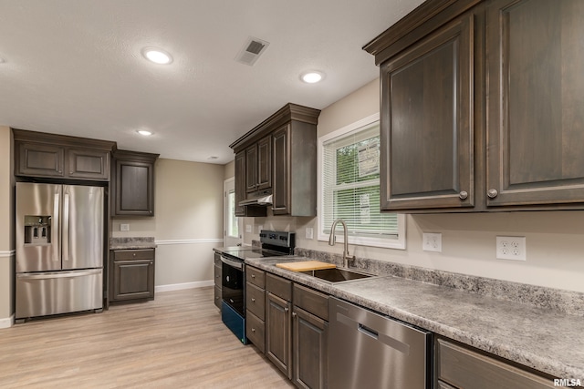 308 Prentice Ave, Carterville, IL 62918 - kitchen with appliances with stainless steel finishes, a sink, baseboards, under cabinet range hood, and light wood-type flooring