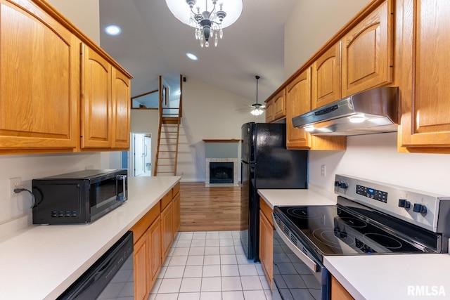 1021 Meadowlark Dr, Carterville, IL 62918 - kitchen with black appliances, under cabinet range hood, vaulted ceiling, light tile patterned floors, and light countertops