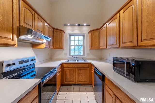 1021 Meadowlark Dr, Carterville, IL 62918 - kitchen with appliances with stainless steel finishes, under cabinet range hood, a sink, light tile patterned floors, and light countertops