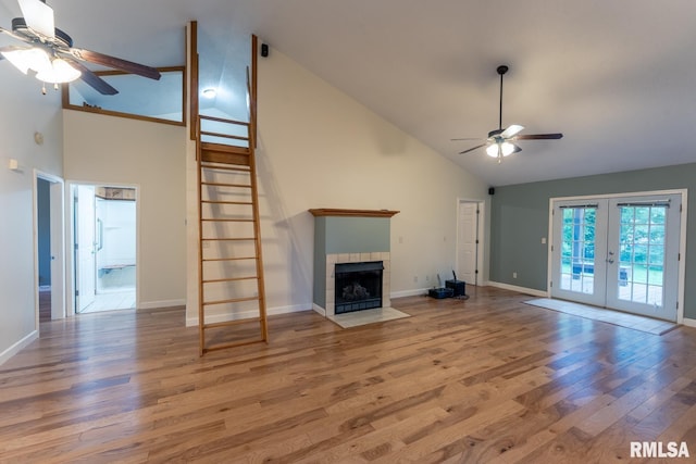 1021 Meadowlark Dr, Carterville, IL 62918 - unfurnished living room featuring a ceiling fan, high vaulted ceiling, french doors, wood finished floors, and a tile fireplace