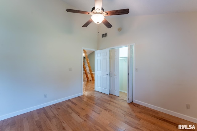 1021 Meadowlark Dr, Carterville, IL 62918 - unfurnished bedroom featuring baseboards, light wood-style flooring, a towering ceiling, a closet, and ceiling fan