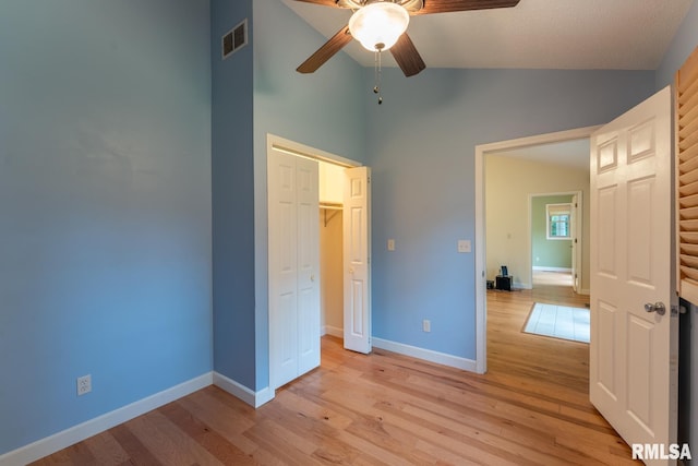 1021 Meadowlark Dr, Carterville, IL 62918 - unfurnished bedroom featuring high vaulted ceiling, light wood finished floors, baseboards, a closet, and a ceiling fan