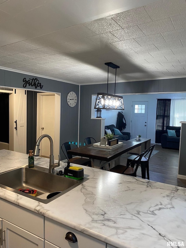 717 E Main St, Benton, IL 62812 - kitchen with a sink, crown molding, white cabinets, light countertops, and wood finished floors