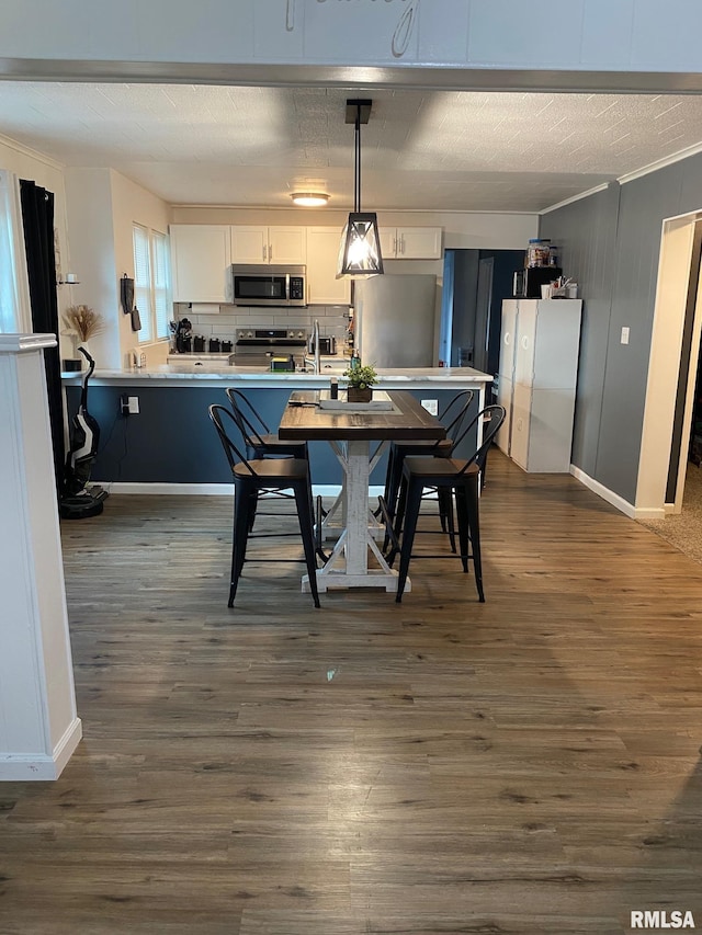 717 E Main St, Benton, IL 62812 - dining space with dark wood-type flooring, crown molding, and baseboards