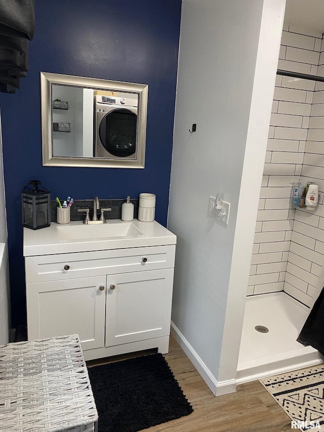 717 E Main St, Benton, IL 62812 - full bath featuring wood finished floors, a stall shower, washer / dryer, vanity, and baseboards