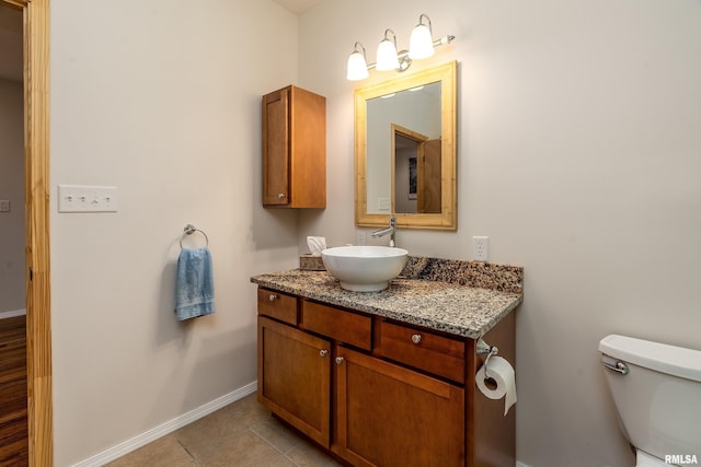 bathroom featuring baseboards, toilet, vanity, and tile patterned flooring